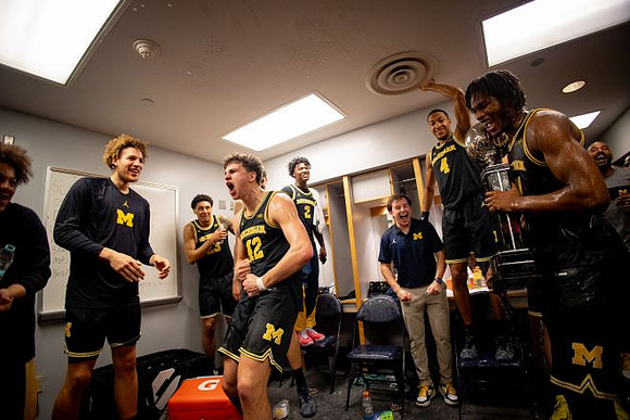 Morez Johnson Jr. (21), Big Ten Championship Trophy, and Michigan Team