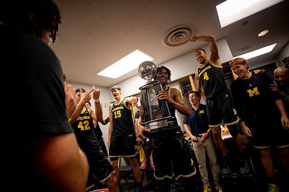 Morez Johnson Jr. (21), Big Ten Championship Trophy, and Michigan Team
