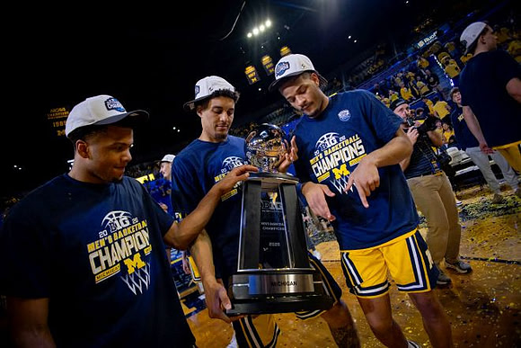 Trey McKenney (1), Yaxel Lendeborg (23), Roddy Gayle Jr. (11), and Big Ten Championship Trophy