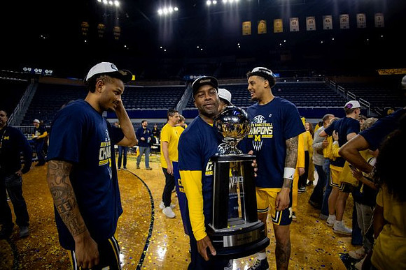 Roddy Gayle Jr. (11), Yaxel Lendeborg (23), and Big Ten Championship Trophy