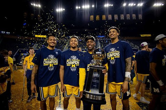 Roddy Gayle Jr. (11), Trey McKenney (1), Yaxel Lendeborg (23), and Big Ten Championship Trophy
