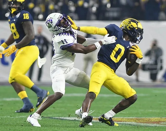 Eyabi Anoma Okie (18) and Mike Sainristil (0)