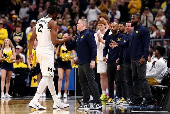 Morez Johnson Jr. (21), Dusty May, and Michigan Team