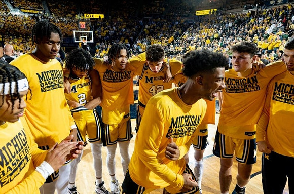 Jace Howard (25) and Michigan Team