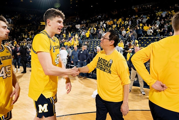 Cooper Smith (45), Will Tschetter (42), and Michigan President Santa Ono