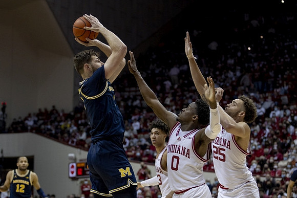 Hunter Dickinson (1) and DeVante' Jones (12)