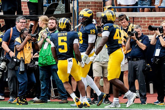Savion Hiter (5), Bryce Underwood (19), and Jalen Hoffman (42)