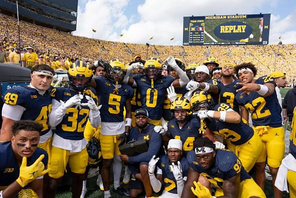 Jyaire Hill (0) and Michigan Team