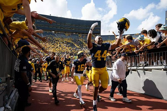 Eli Owens (44), Brayden Fowler-Nicolosi (16), and Michigan Team