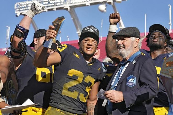 Josh Priebe (68), Jordan Marshall (23), and ReliaQuest Bowl MVP Trophy