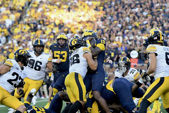 Jake Guarnera (53), Bryce Underwood (19), and Jalen Hoffman (42)