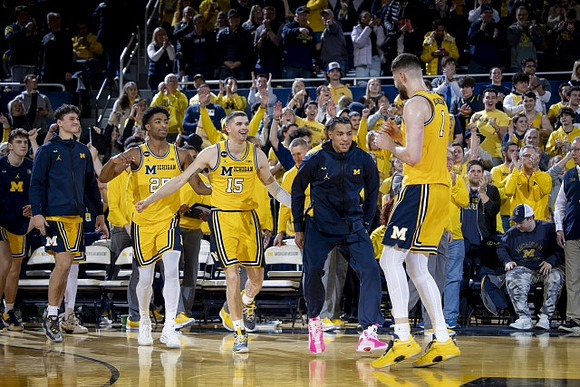 Hunter Dickinson (1) and Michigan Team