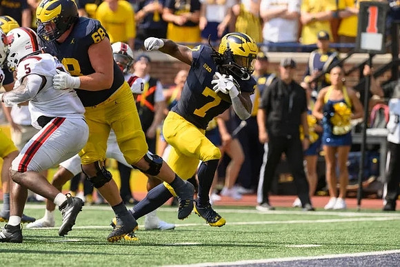Josh Priebe (68) and Donovan Edwards (7)
