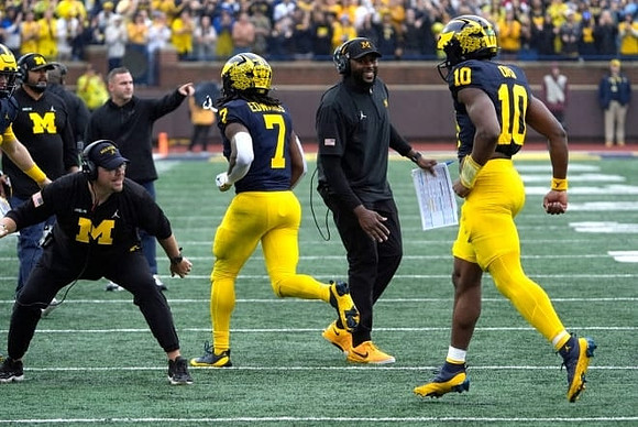 Donovan Edwards (7), Alex Orji (10), and Sherrone Moore
