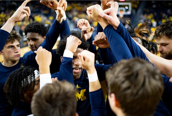 Jace Howard (25) and Michigan Team
