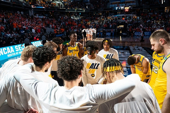 Jace Howard (25) and Michigan Team