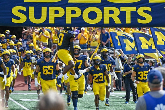 Mike Sainristil (0) and Michigan Team