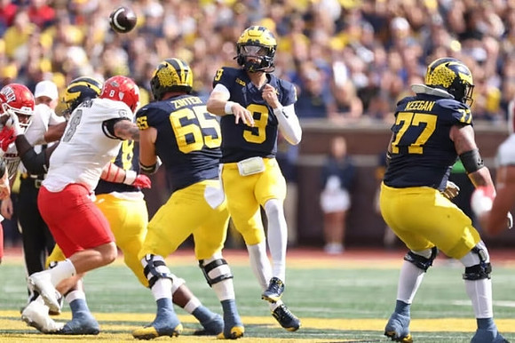 Zak Zinter (65), J.J. McCarthy (9), and Trevor Keegan (77)