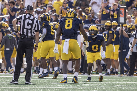 Josaiah Stewart (5), Derrick Moore (8), and Mike Sainristil (0)
