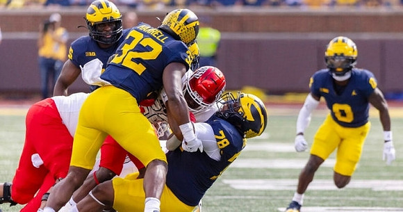 Jaylen Harrell (32), Kenneth Grant (78), and Mike Sainristil (0)
