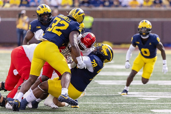 Jaylen Harrell (32), Kenneth Grant (78), and Mike Sainristil (0)