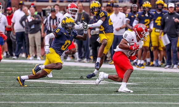 Mike Sainristil (0) and Jyaire Hill (20)