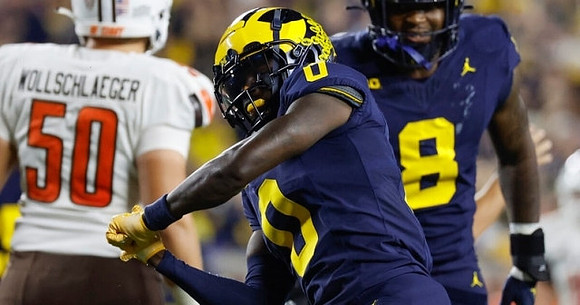 Mike Sainristil (0) and Derrick Moore (8)