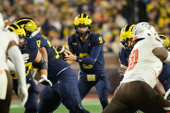 Trevor Keegan (77) and J.J. McCarthy (9)