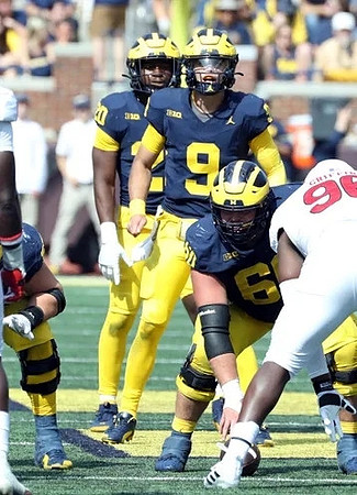 Kalel Mullings (20), J.J. McCarthy (9), and Zak Zinter (65)