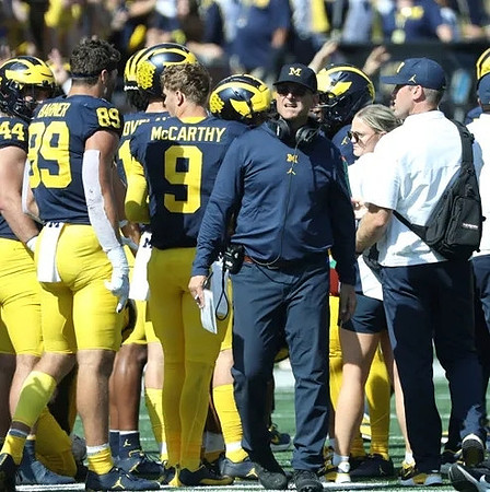 Max Bredeson (44), AJ Barner (89), J.J. McCarthy (9), and Jim Harbaugh
