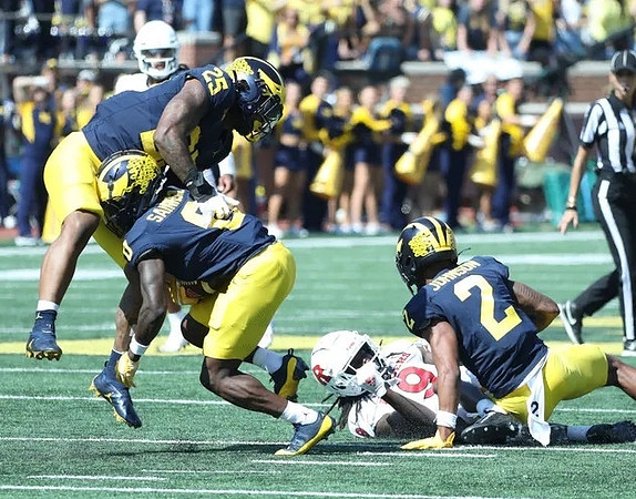 Junior Colson (25), Mike Sainristil (0), and Will Johnson (2)