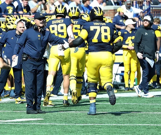 Jim Harbaugh, AJ Barner (89), and Myles Hinton (78)