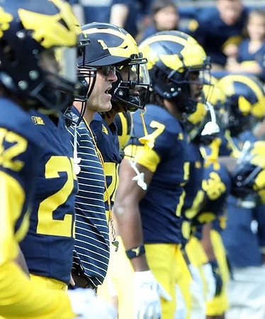 Tavierre Dunlap (22), Jim Harbaugh, and Donovan Edwards (7)