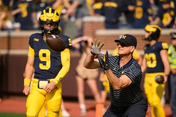 J.J. McCarthy (9) and Jim Harbaugh