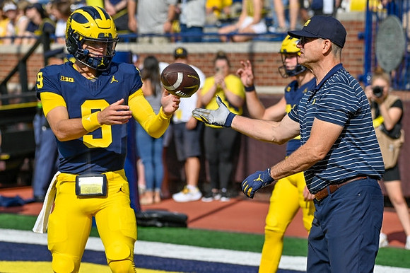 J.J. McCarthy (9) and Jim Harbaugh