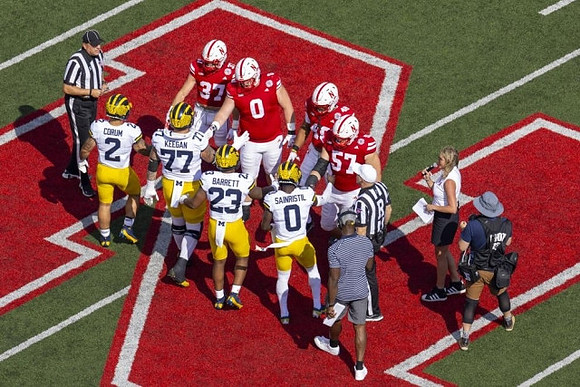 Blake Corum (2), Trevor Keegan (77), Michael Barrett (23), and Mike Sainristil (0)