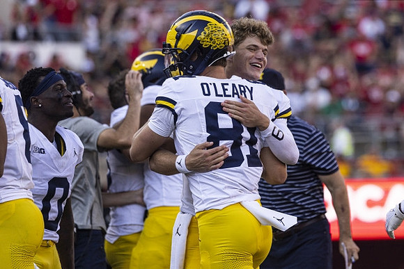 Mike Sainristil (0), J.J. McCarthy (9), and Peyton O'Leary (81)