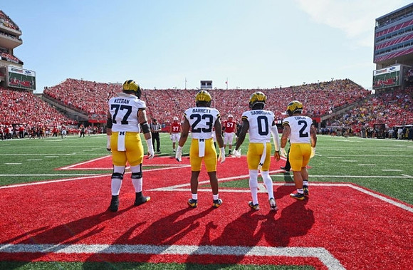 Trevor Keegan (77), Michael Barrett (23), Mike Sainristil (0), and Blake Corum (2)