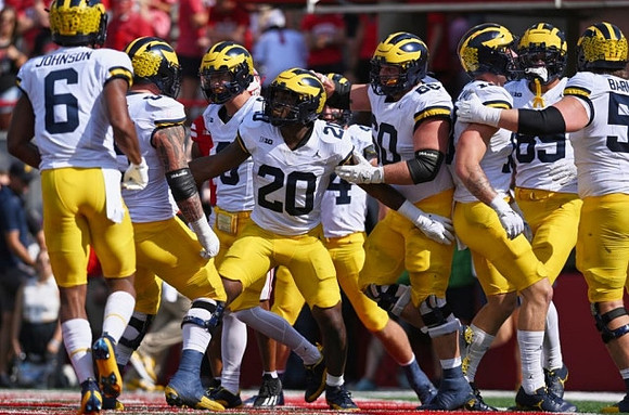 Kalel Mullings (20) and Michigan Team