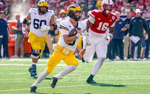 Drake Nugent (60) and J.J. McCarthy (9)