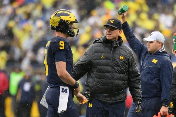 J.J. McCarthy (9) and Jim Harbaugh