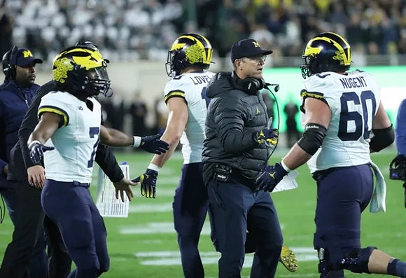 Sherrone Moore, Donovan Edwards (7), Colston Loveland (18), Jim Harbaugh, and Drake Nugent (60)