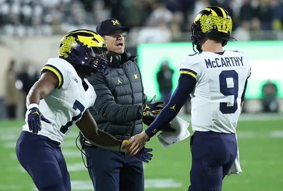 Donovan Edwards (7), Jim Harbaugh, and J.J. McCarthy (9)