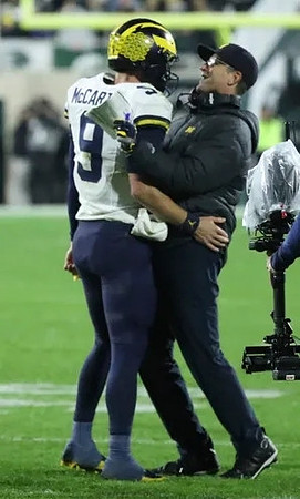 J.J. McCarthy (9) and Jim Harbaugh