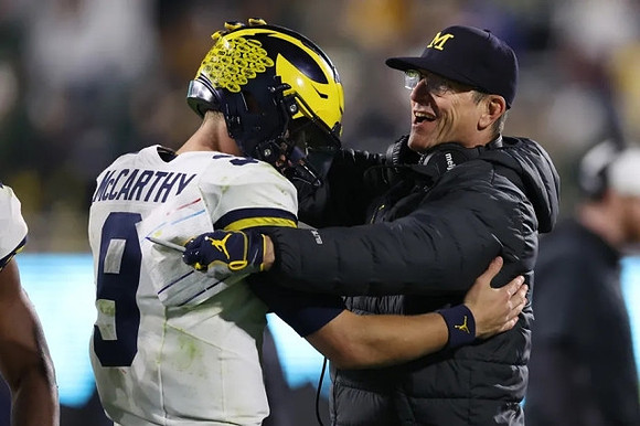 J.J. McCarthy (9) and Jim Harbaugh