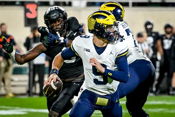 J.J. McCarthy (9) and Trevor Keegan (77)