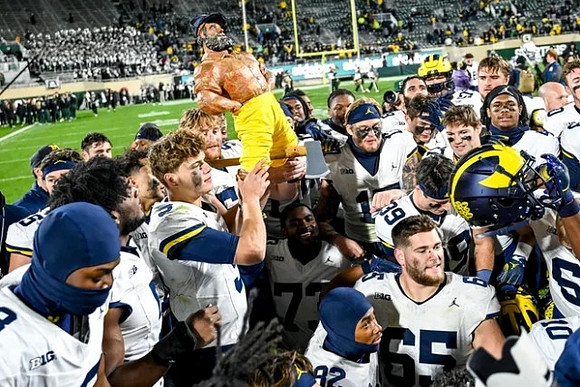 J.J. McCarthy (9), Paul Bunyan Trophy, and Michigan Team