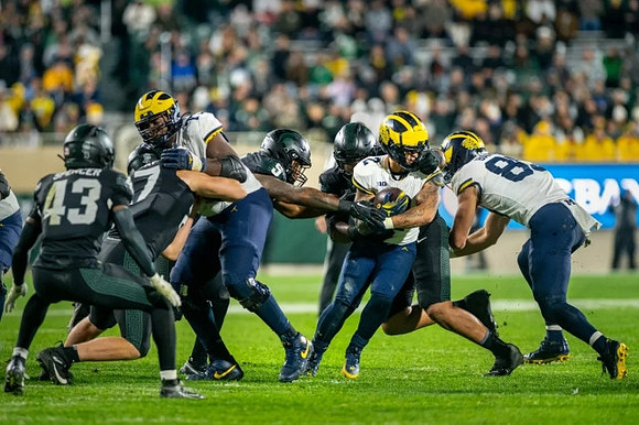 LaDarius Henderson (73), J.J. McCarthy (9), and AJ Barner (89)