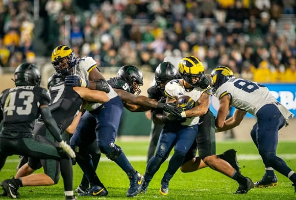 LaDarius Henderson (73), J.J. McCarthy (9), and AJ Barner (89)