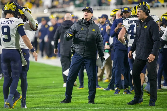 J.J. McCarthy (9), Jim Harbaugh, Max Bredeson (44), and Sherrone Moore